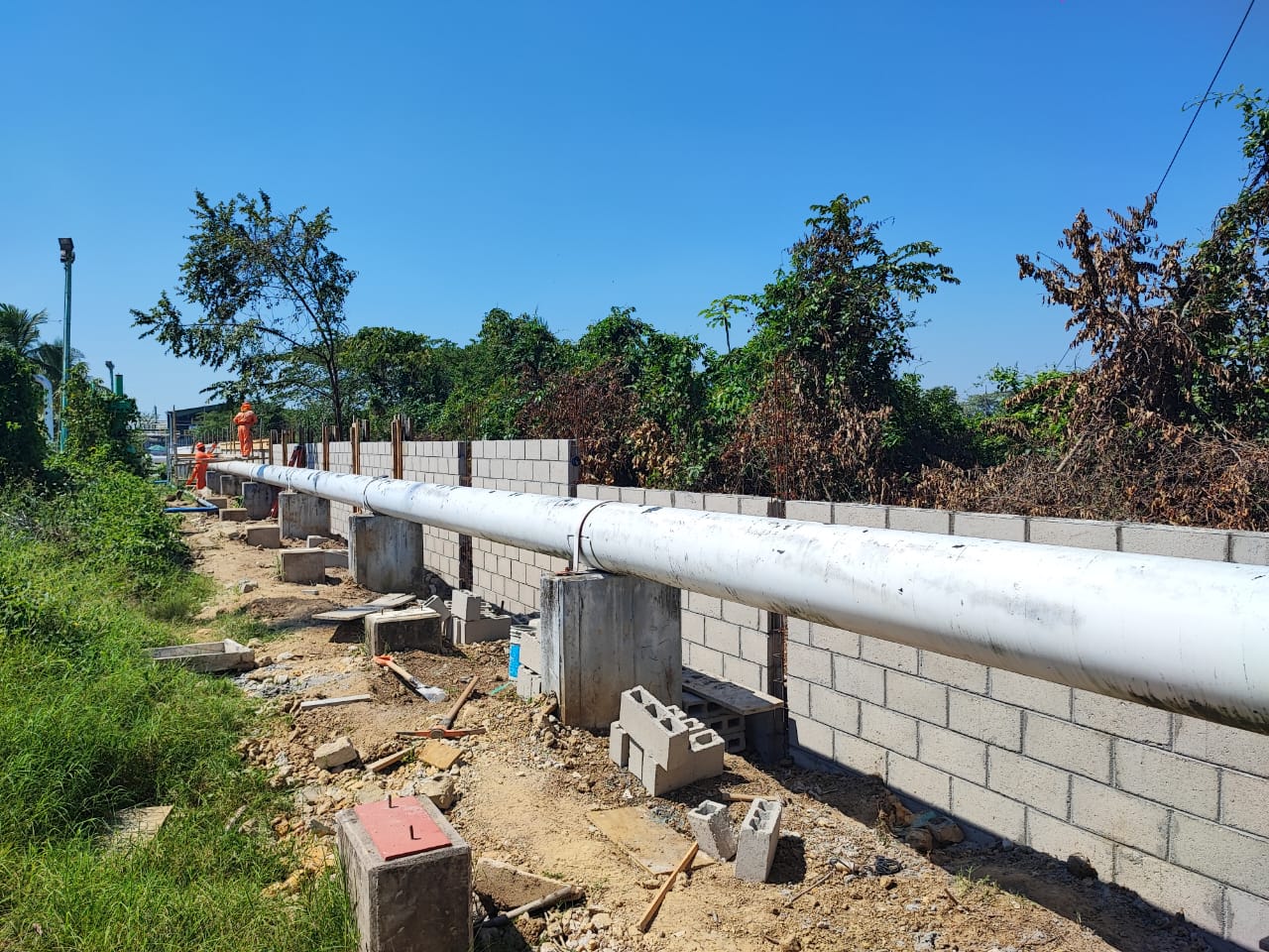 Barda perimetral con tubería de proceso